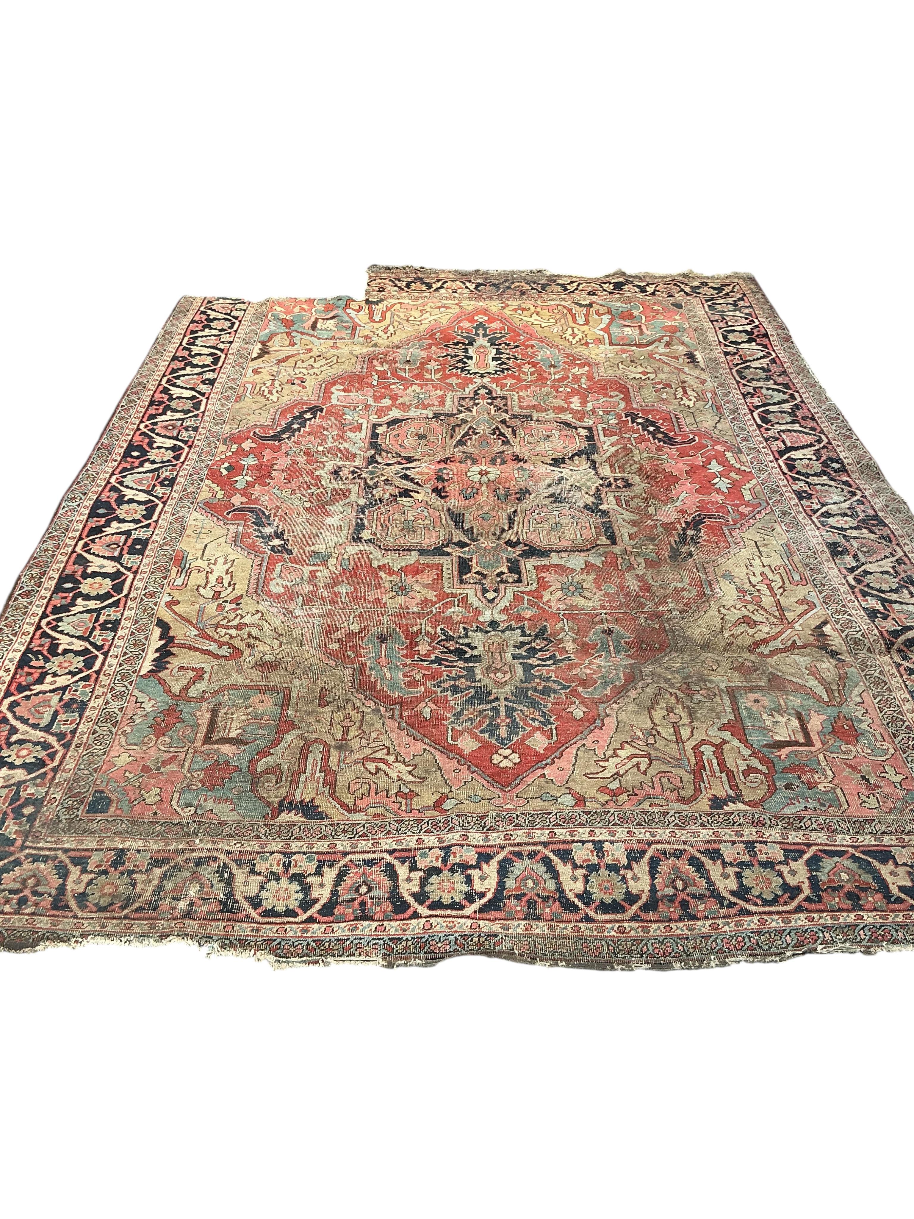 An antique Heriz pink ground carpet, worn and lacking a piece to one corner, 365 x 255cm
